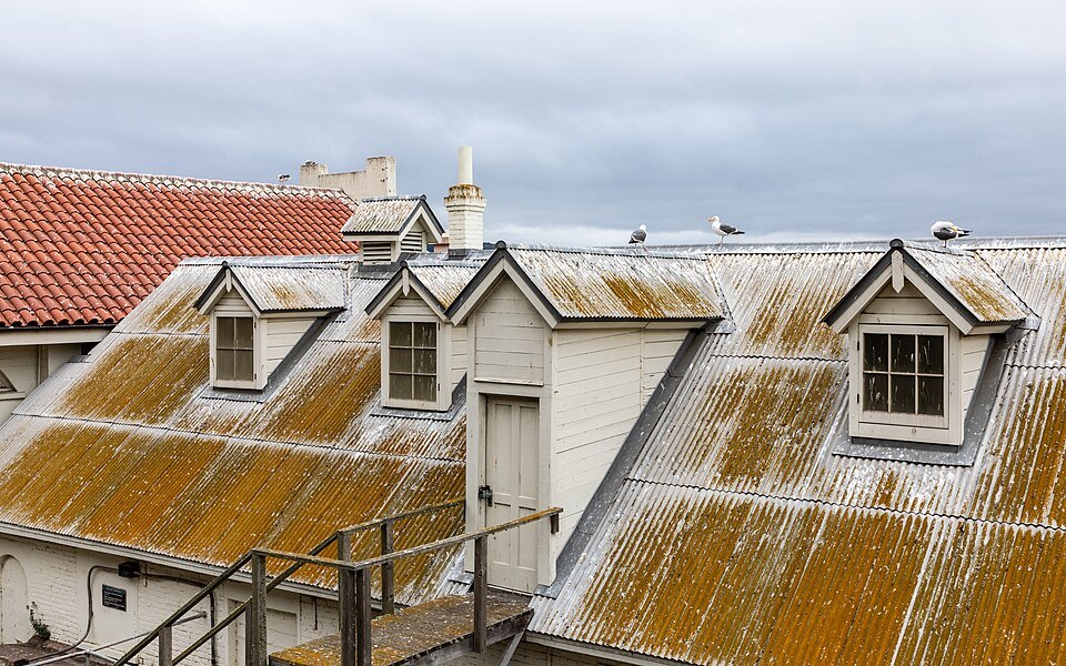 Lichen-covered roofs and dormer windows of the old buildings above the Alcatraz dock