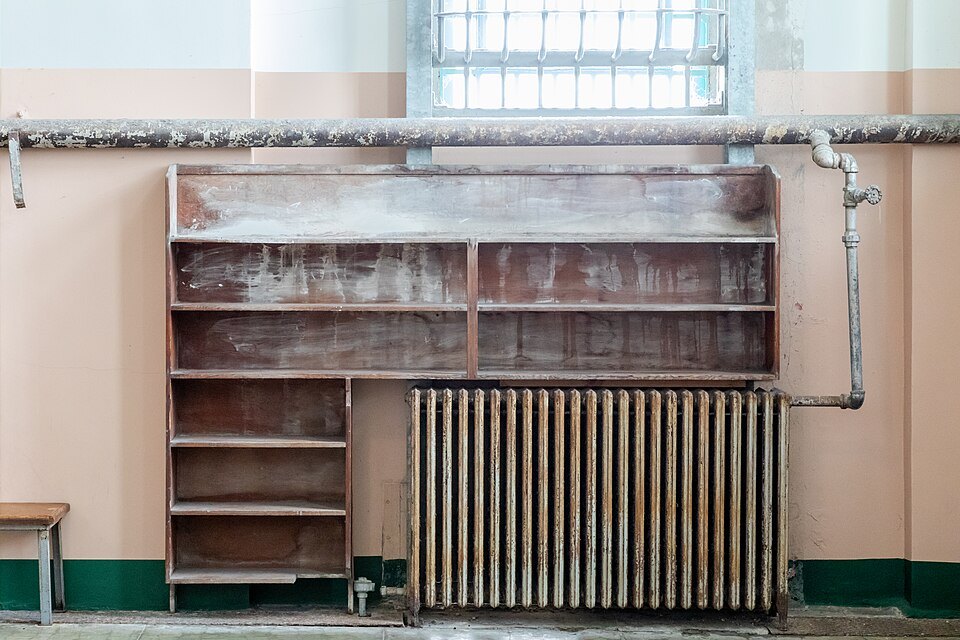 Open shelving and an old radiator under a high window inside the Alcatraz prison buildings