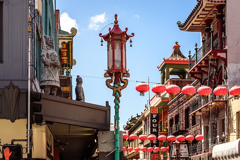A lantern-topped street lamp beneath pagoda-roofed balconies and rows of red lanterns
