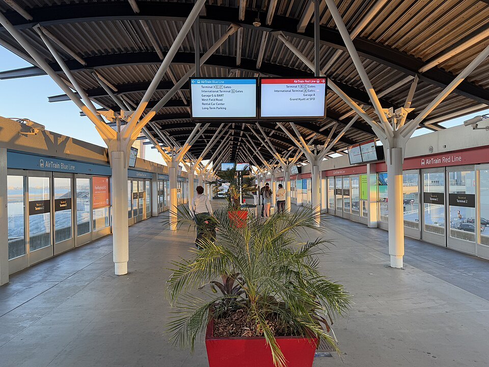 The AirTrain platform at an SFO terminal, glass walls and a potted palm