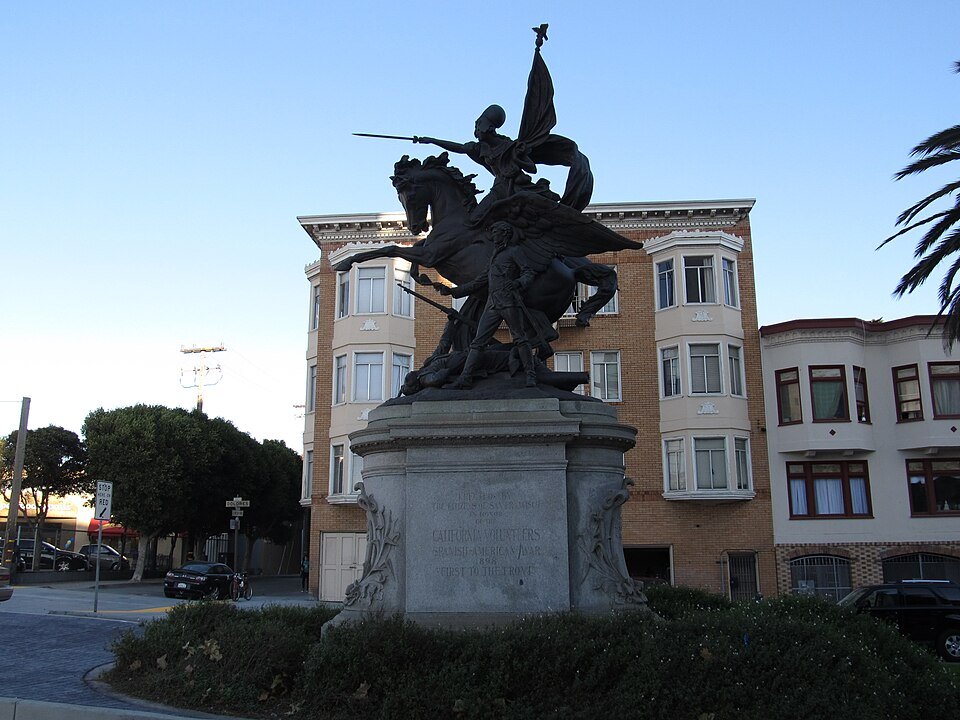 An equestrian statue on a Mission District square, bay-windowed houses behind