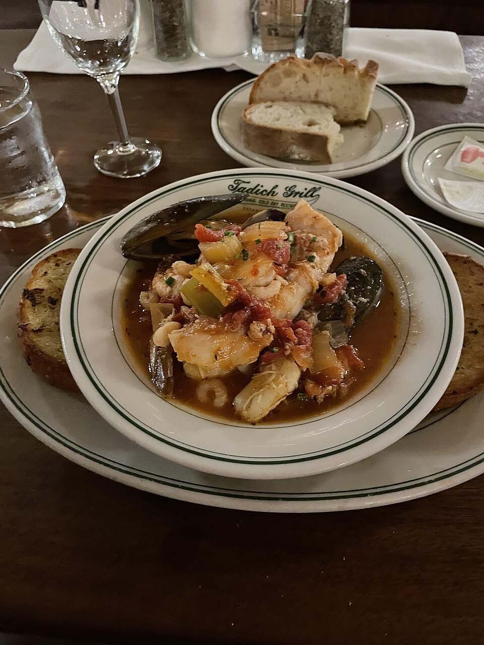 A bowl of cioppino, shellfish and fish in tomato broth, with sourdough bread