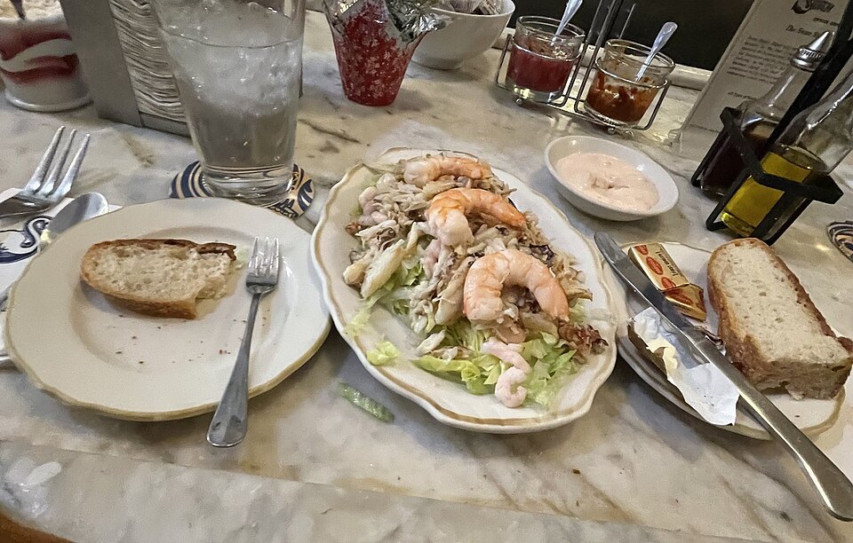 Seafood salad, bread and sauces on a marble counter