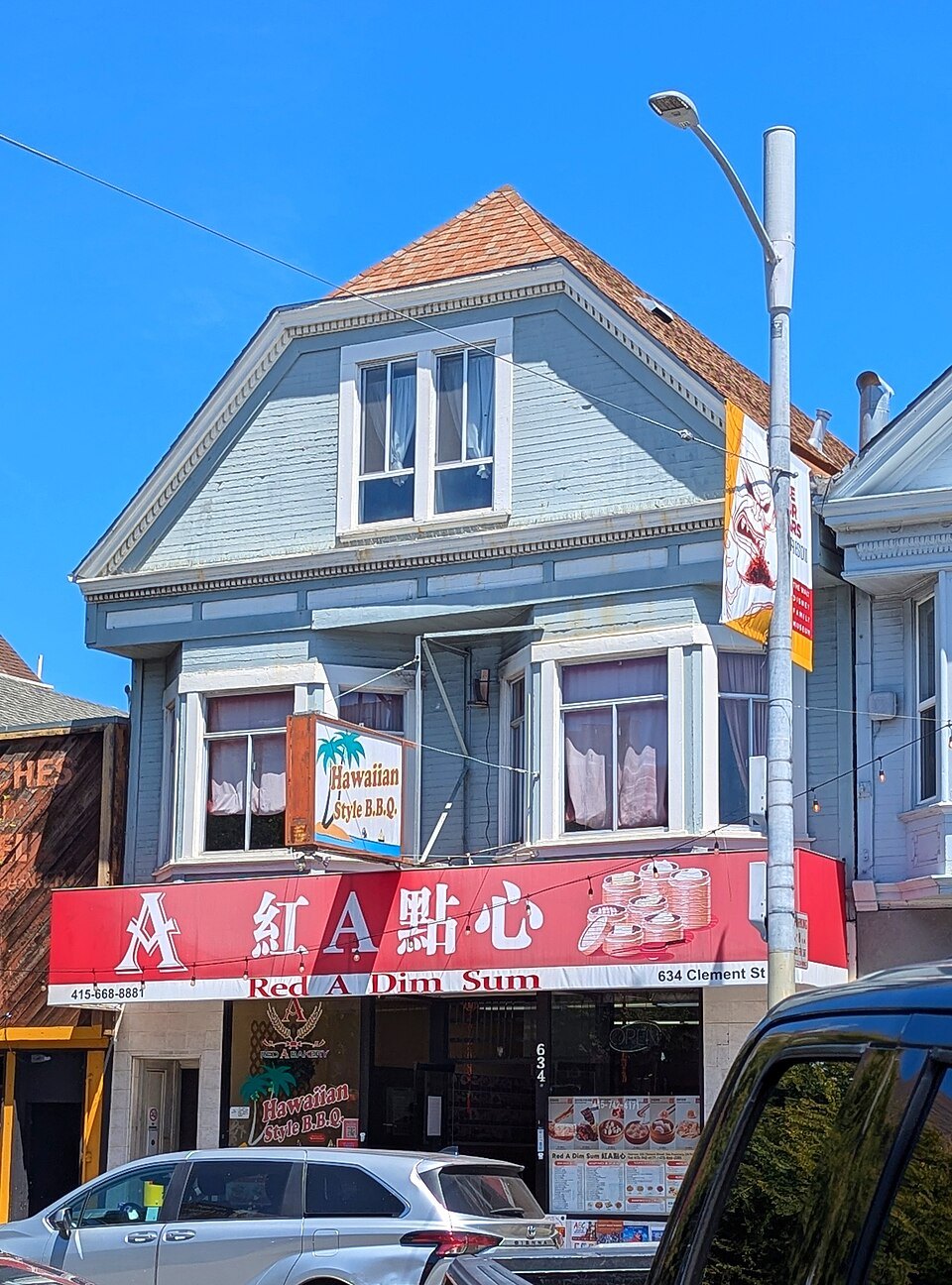 A dim sum restaurant on a San Francisco corner, its red sign under bay windows