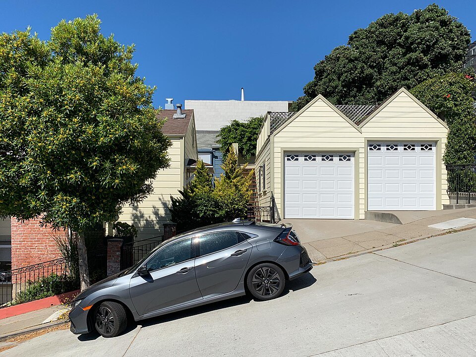 A steep street in the western hills, a car parked across the slope