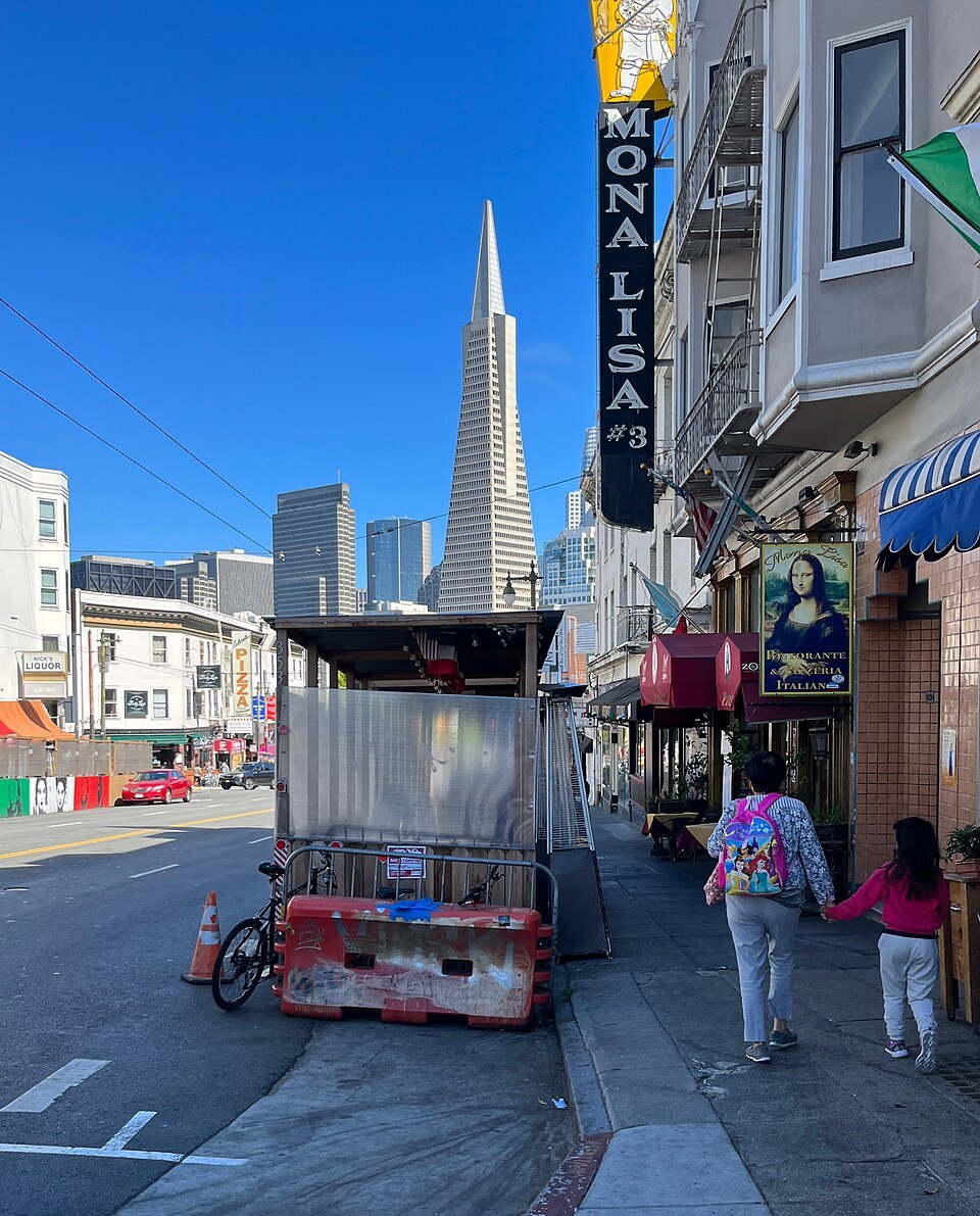 The Transamerica Pyramid over the signs of Columbus Avenue in North Beach