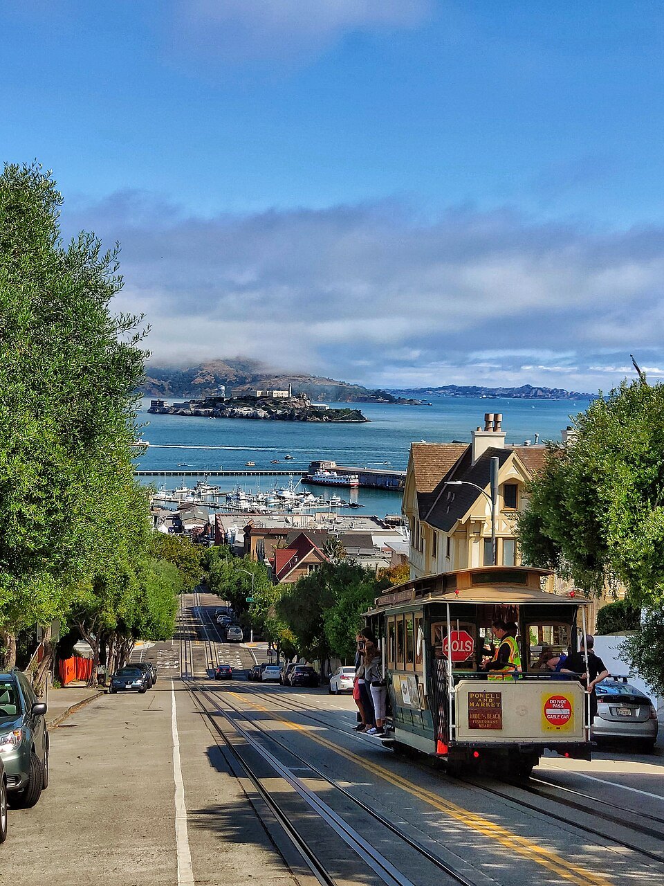 A cable car on Hyde Street, with Alcatraz and the bay at the bottom of the hill