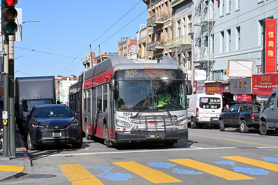 An electric trolleybus crossing a Chinatown intersection