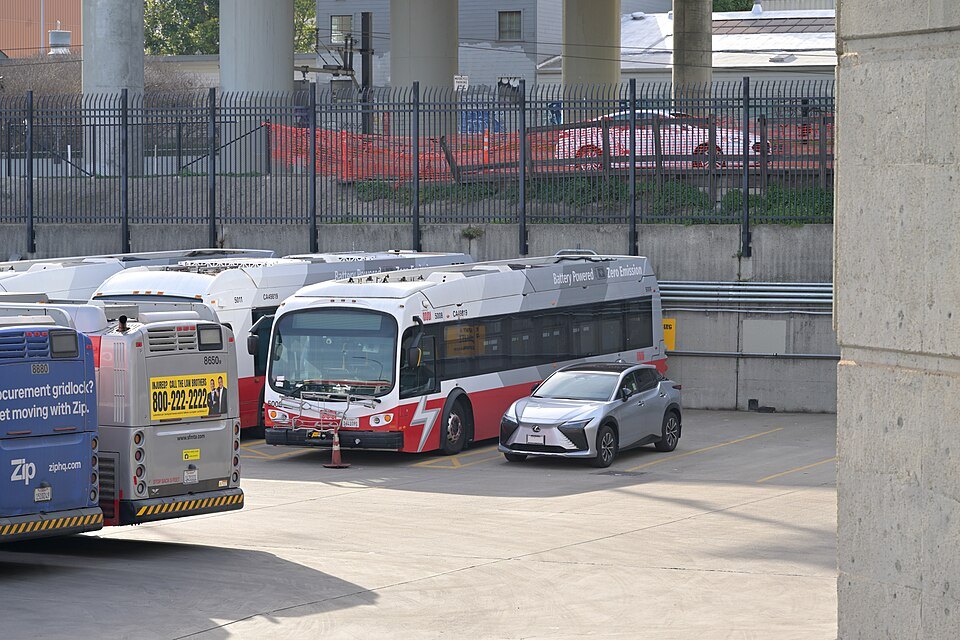 Buses parked at a transit yard under a freeway