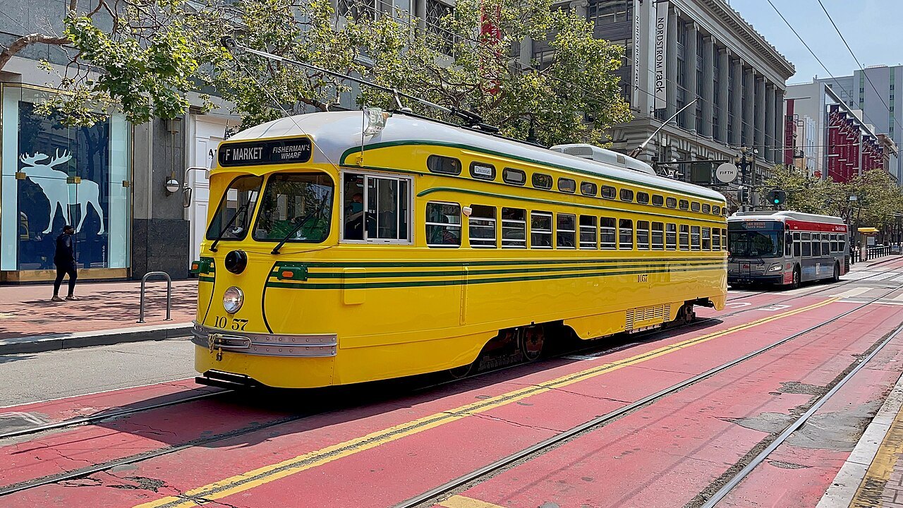 A yellow heritage streetcar on Market Street's red transit lane