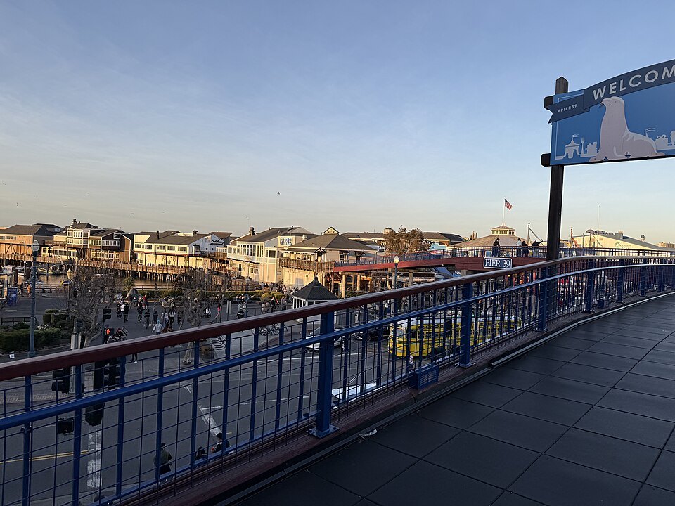 The walkway toward Pier 39's welcome sign at dusk