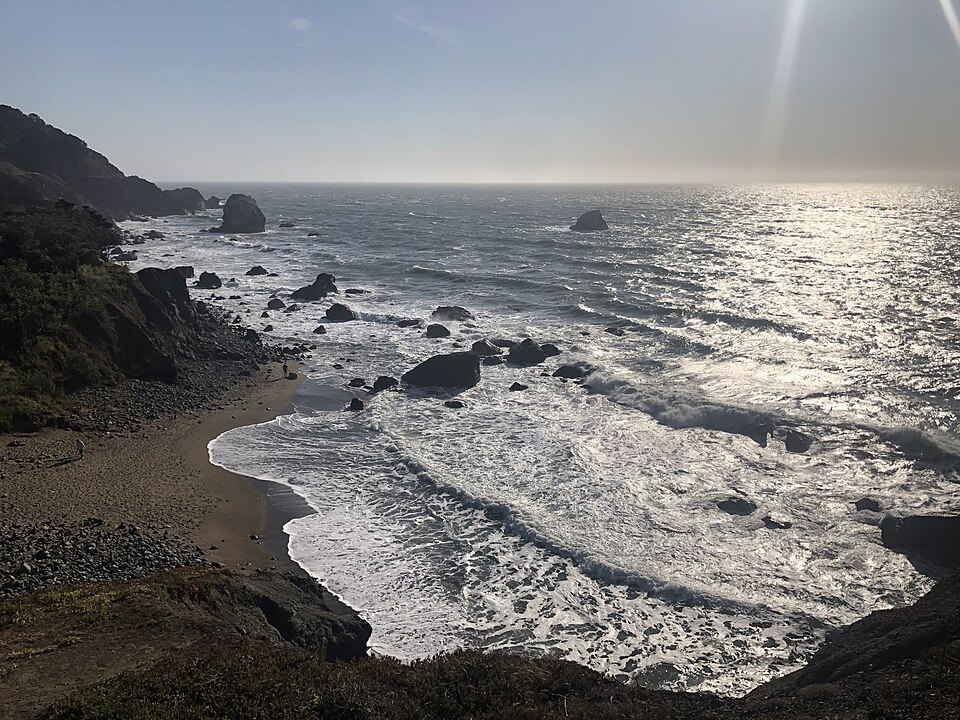 Waves breaking on the rocks below the Lands End Lookout, the sea glittering
