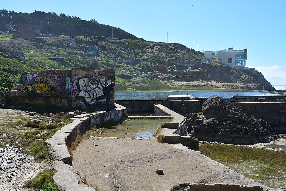 Graffiti on a ruined wall at the Sutro Baths, the pools behind it