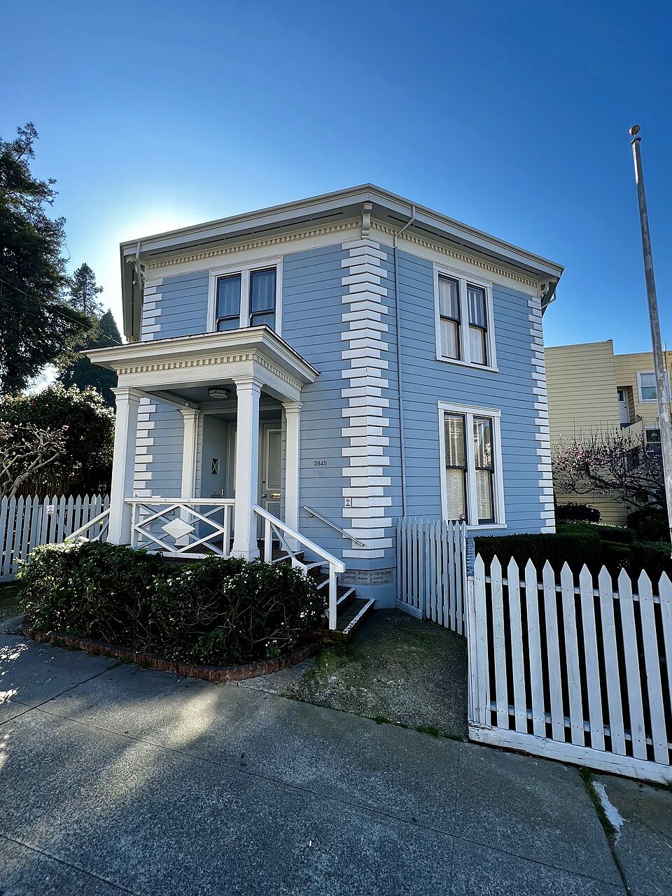The McElroy Octagon House, pale blue behind its white picket fence