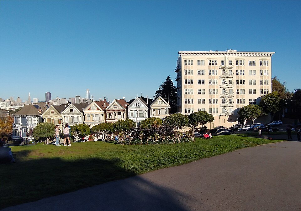 The Painted Ladies beside a taller apartment building at the edge of Alamo Square