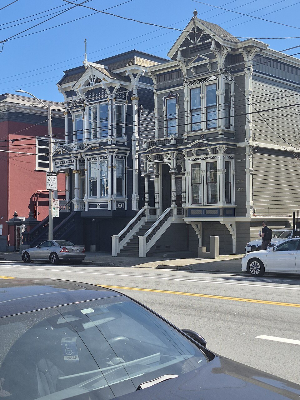 A dark-painted Victorian townhouse with carved trim and a tall stoop