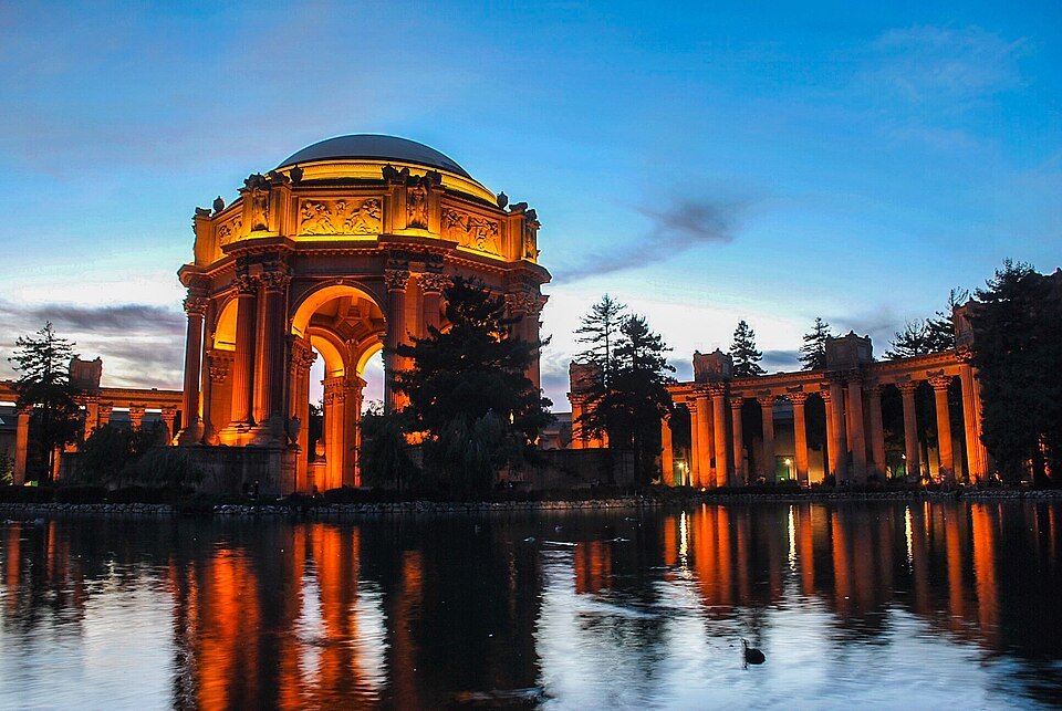 The Palace of Fine Arts lit up at dusk, doubled in the lagoon