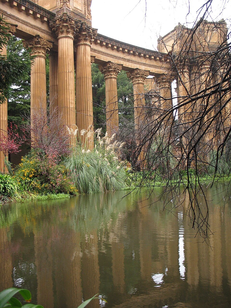 The colonnade reflected in the lagoon behind reeds and willows