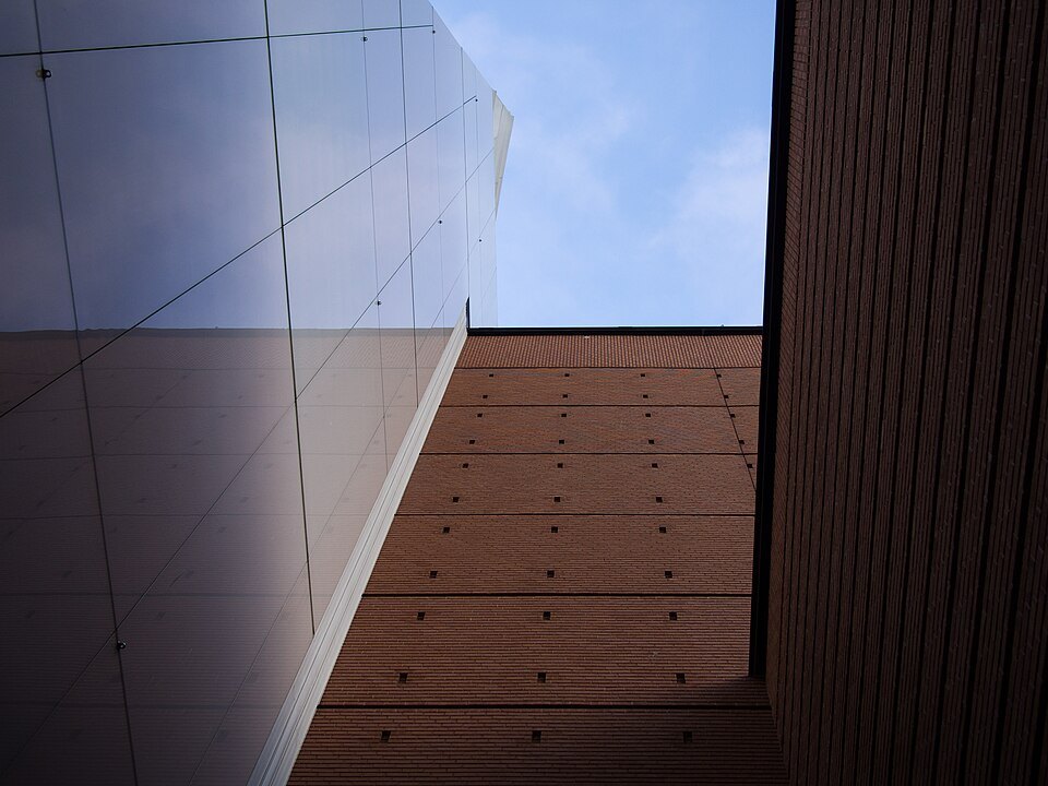 Looking straight up a museum wall into a slice of sky