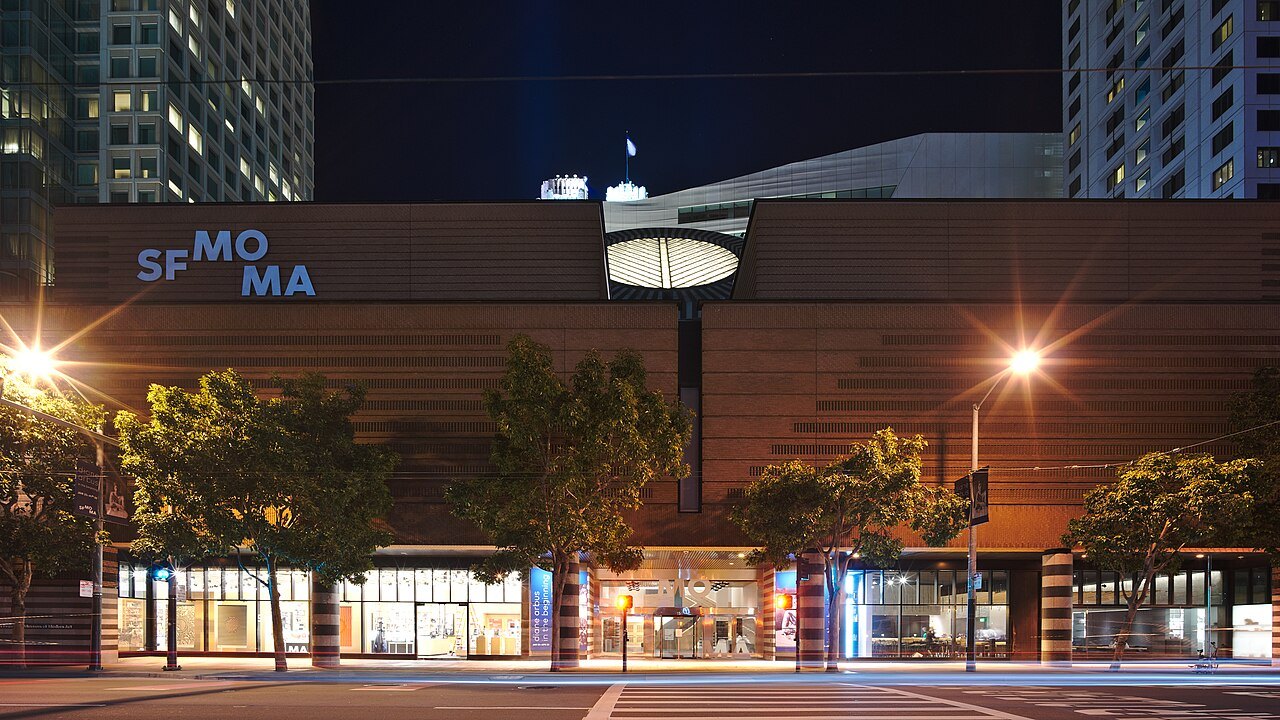 SFMOMA's front on Third Street at night, its name lit over the entrance
